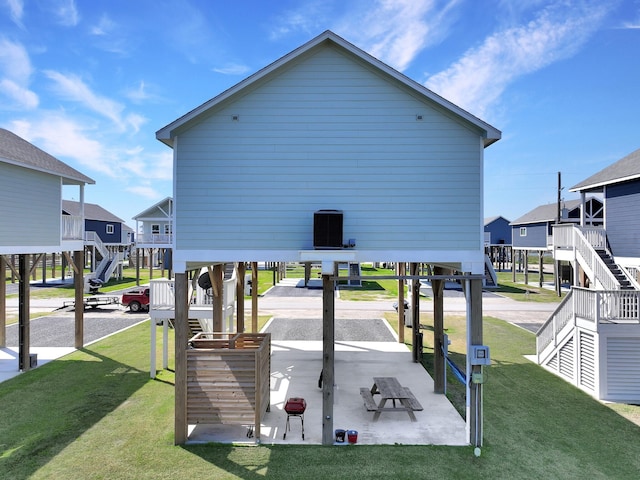 exterior space featuring a carport, stairway, a lawn, and a patio area