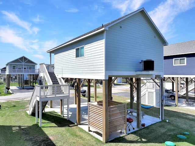 exterior space with stairway, a carport, a yard, and a patio area