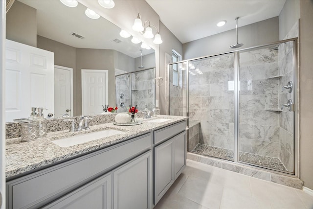 bathroom featuring visible vents, a stall shower, a sink, tile patterned flooring, and double vanity