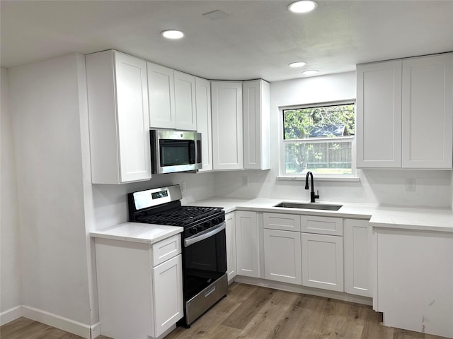 318 S Fulton St, Texas City, TX 77591 - kitchen with a sink, stainless steel appliances, recessed lighting, white cabinetry, and light wood-type flooring
