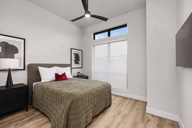 bedroom with baseboards, light wood finished floors, and ceiling fan