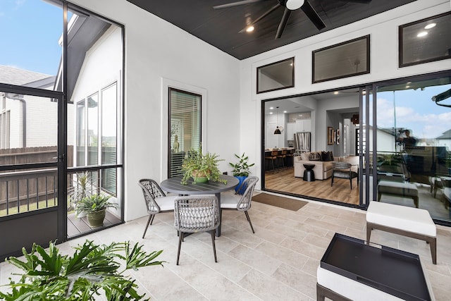 sunroom / solarium with a ceiling fan