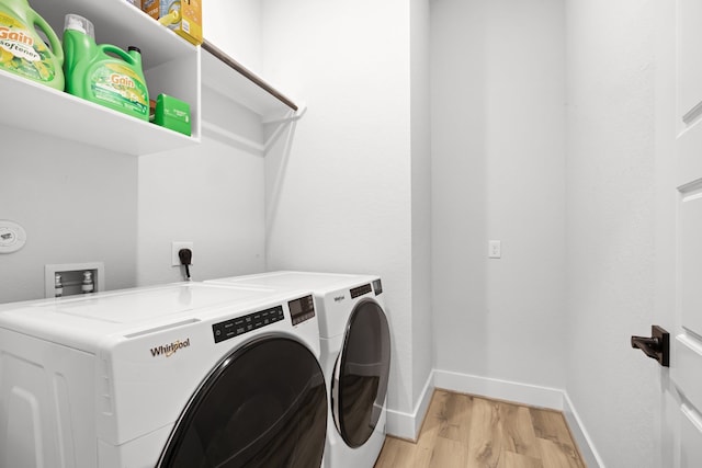 washroom featuring laundry area, baseboards, independent washer and dryer, and light wood finished floors