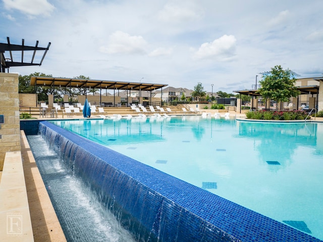 community pool with a patio area and fence