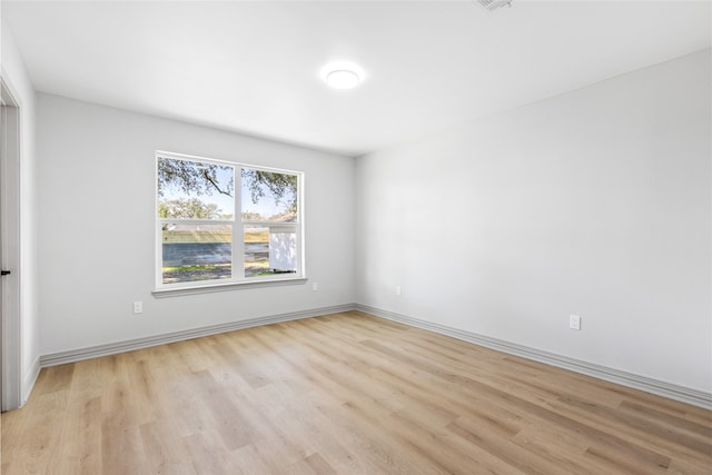 spare room with light wood-type flooring and baseboards