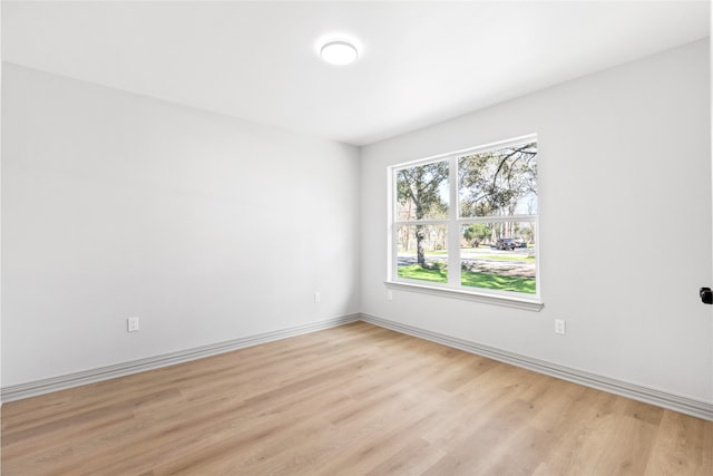 unfurnished room with baseboards and light wood-style flooring