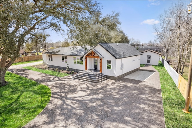 view of front of property with driveway and fence