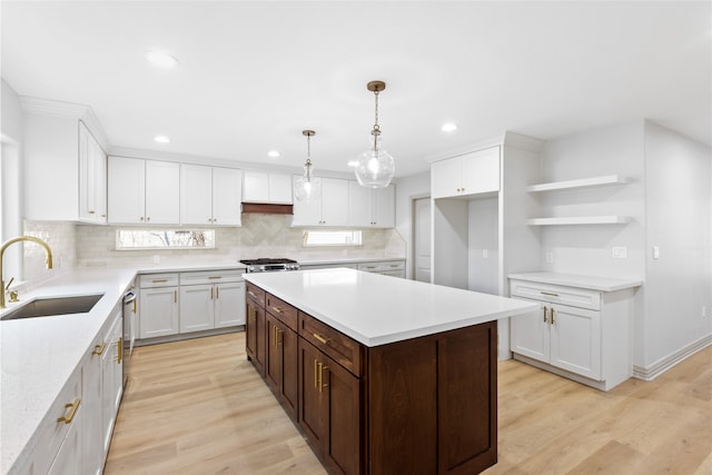 kitchen featuring a sink, light wood-style floors, white cabinets, and light countertops