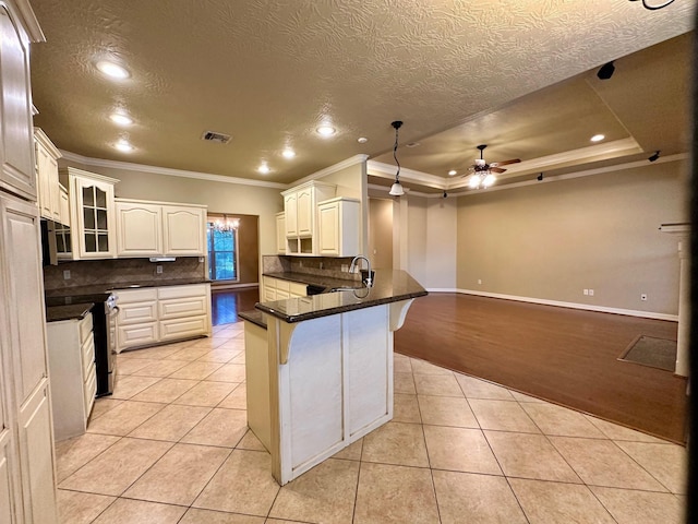 kitchen with a kitchen bar, ornamental molding, range with electric stovetop, a peninsula, and light tile patterned flooring