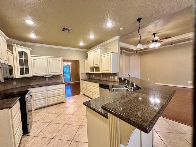 kitchen featuring a peninsula, light tile patterned floors, appliances with stainless steel finishes, and a sink