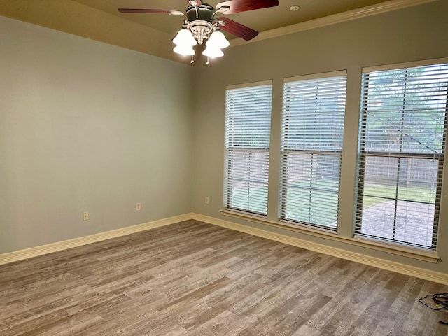 empty room with wood finished floors, baseboards, and a healthy amount of sunlight