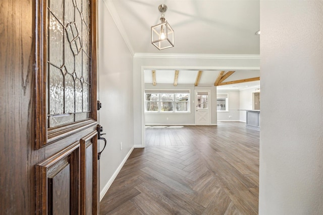 entryway with beamed ceiling, crown molding, and baseboards