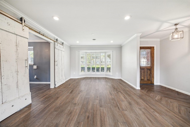 unfurnished living room with dark wood-style floors, crown molding, and a barn door