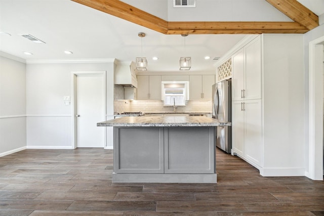 kitchen featuring visible vents, stainless steel refrigerator with ice dispenser, a sink, light stone counters, and backsplash