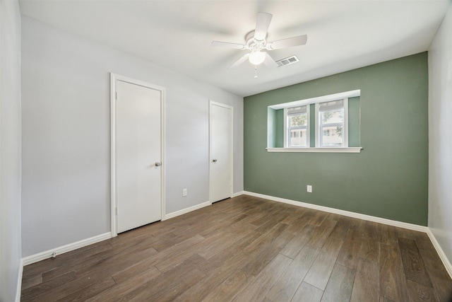 unfurnished bedroom featuring visible vents, ceiling fan, baseboards, and wood finished floors