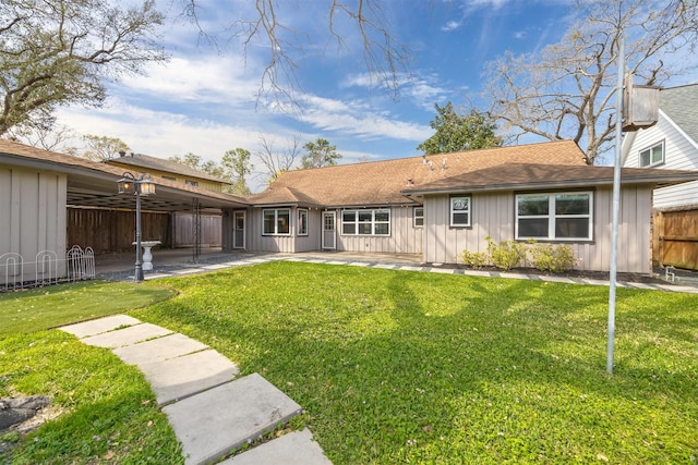 back of property featuring a patio, a lawn, board and batten siding, and fence