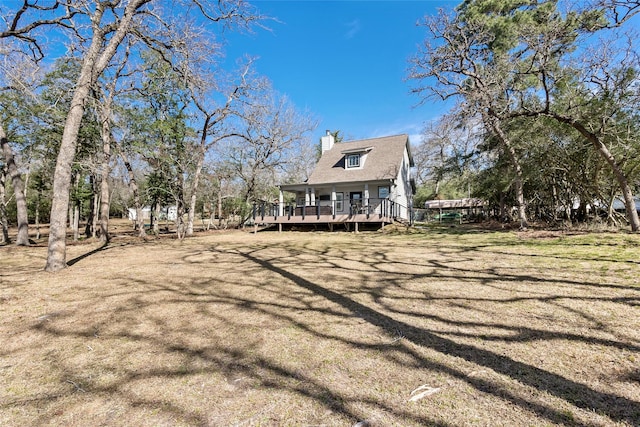 rear view of property with a deck and a chimney