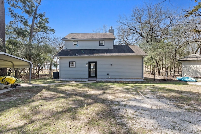 rear view of property with a carport, cooling unit, a chimney, and fence