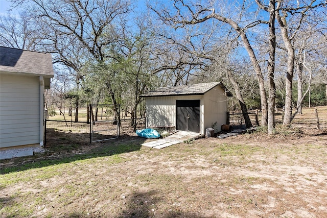 exterior space with an outbuilding, a gate, a storage unit, and fence