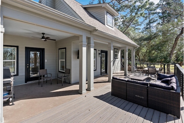 deck with outdoor dining space, an outdoor hangout area, and a ceiling fan