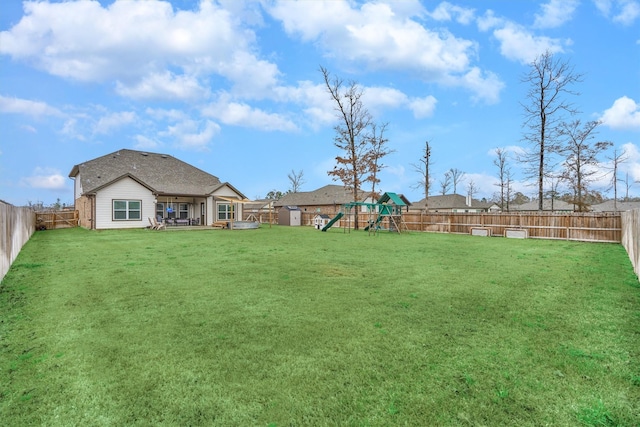 view of yard with a patio area, a fenced backyard, and a playground