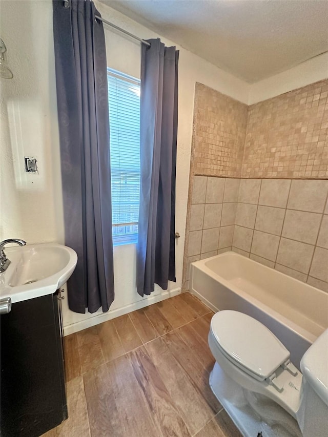 bathroom featuring toilet, vanity, bathtub / shower combination, and wood finished floors