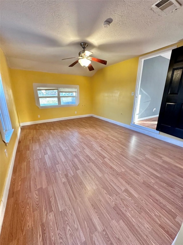 empty room with visible vents, baseboards, light wood-style flooring, and a ceiling fan