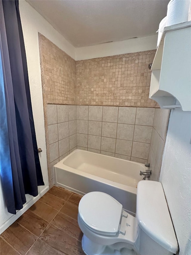 bathroom with toilet and bathing tub / shower combination