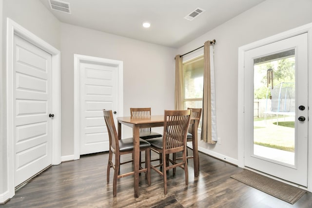 dining area featuring visible vents, dark wood-type flooring, and baseboards