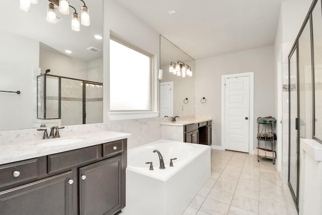 full bathroom featuring a garden tub, two vanities, a stall shower, a sink, and tile patterned flooring