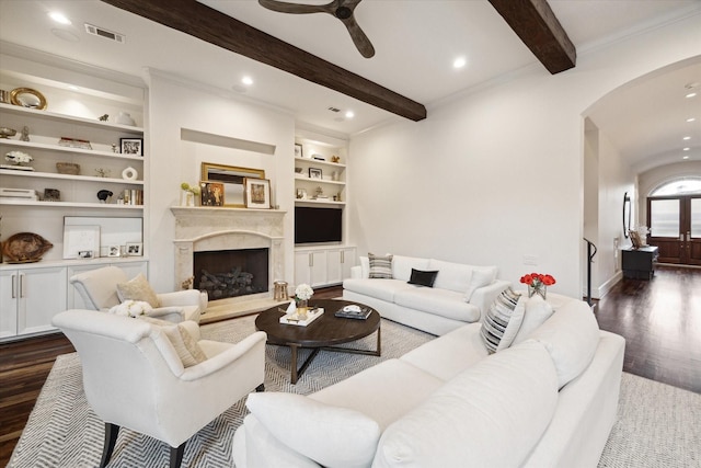 living area with visible vents, beam ceiling, a ceiling fan, dark wood finished floors, and arched walkways