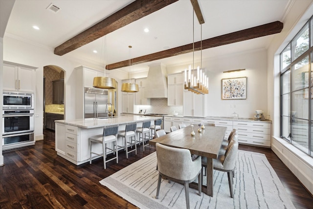 dining area featuring arched walkways, visible vents, beamed ceiling, and dark wood-style floors