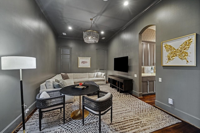 living room featuring arched walkways, dark wood-style floors, baseboards, and ornamental molding