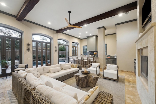 living room featuring stone tile flooring, beam ceiling, french doors, and a premium fireplace