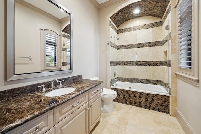 bathroom with tiled shower / bath, vanity, toilet, and crown molding