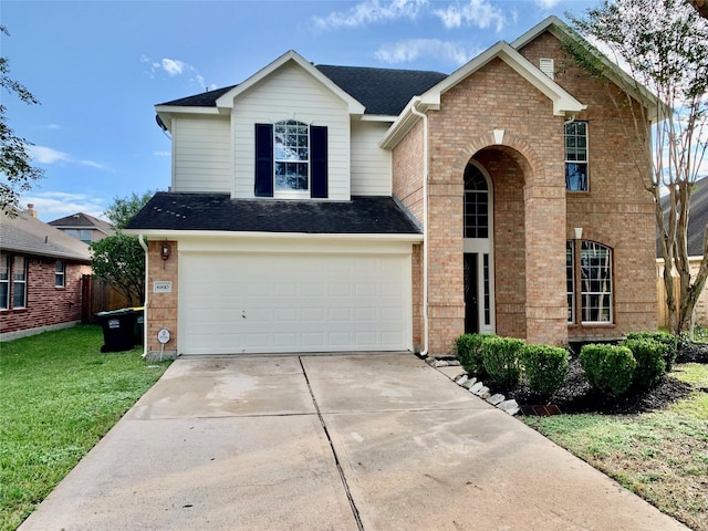 traditional home featuring a front lawn, concrete driveway, brick siding, and an attached garage