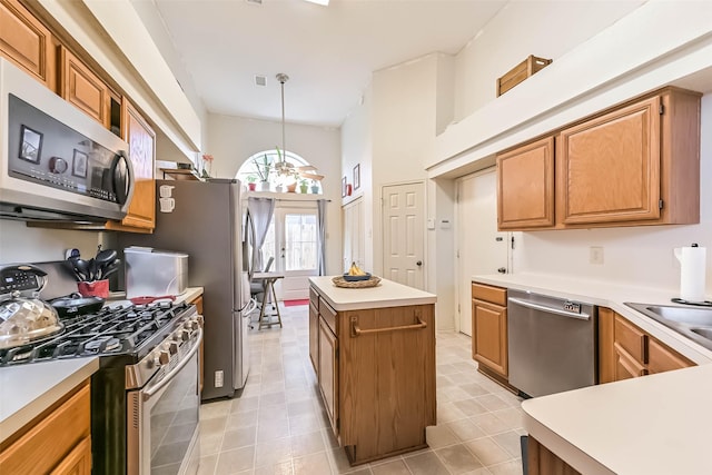 kitchen with a center island, stainless steel appliances, light countertops, and decorative light fixtures