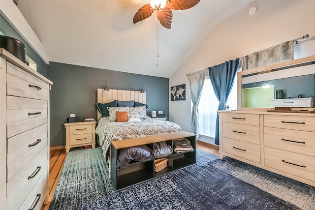 bedroom with vaulted ceiling, wood finished floors, and a textured ceiling