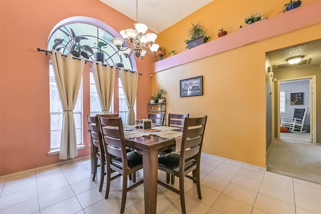 dining area featuring light tile patterned flooring and a chandelier