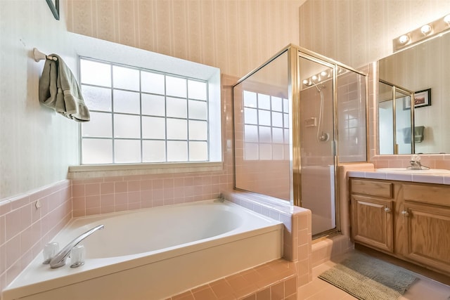 bathroom with a bath, a stall shower, vanity, and wallpapered walls