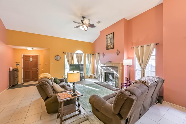 tiled living area featuring visible vents, baseboards, lofted ceiling, a fireplace, and a ceiling fan