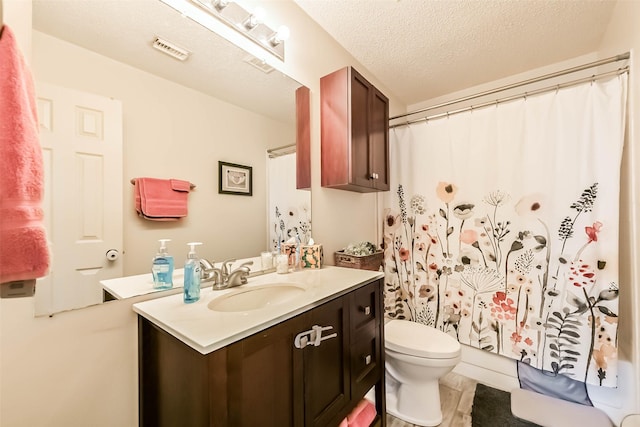 bathroom with vanity, a shower with curtain, visible vents, a textured ceiling, and toilet