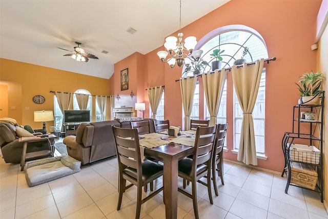 dining room featuring visible vents, ceiling fan with notable chandelier, light tile patterned flooring, and vaulted ceiling