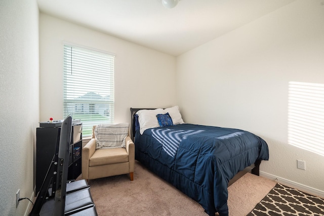 bedroom with a textured wall, baseboards, and carpet floors