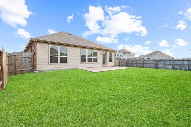 back of property featuring a yard, brick siding, a fenced backyard, and a patio area