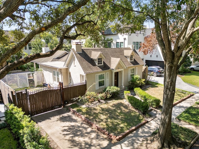 view of front of house with a gate, fence, brick siding, and a chimney