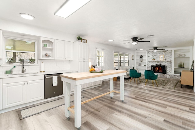 kitchen with visible vents, a sink, white cabinets, light countertops, and dishwasher