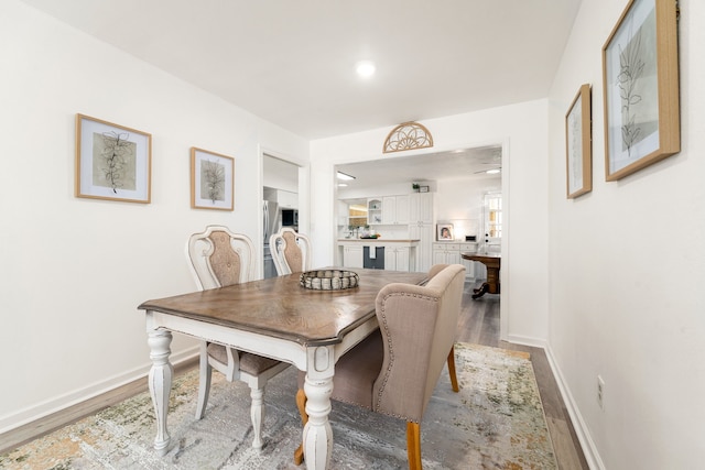 dining space featuring baseboards and wood finished floors