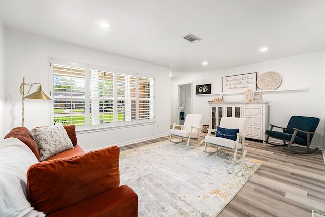 sitting room with recessed lighting, wood finished floors, visible vents, and baseboards