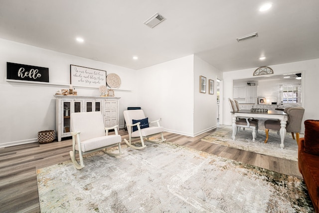 sitting room featuring recessed lighting, wood finished floors, visible vents, and baseboards